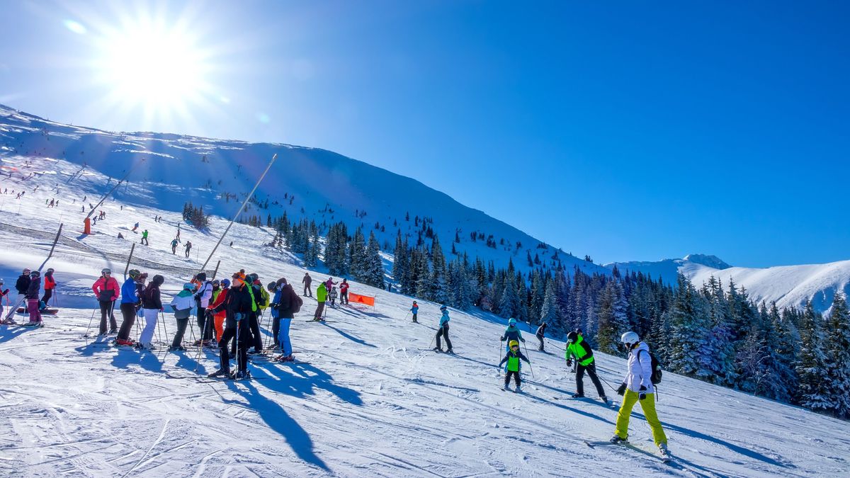 SZLOVÁKIA
Slovakia,,Jasna,-,February,5,,2019:,Winter,Jasna,On,A Slovakia, Jasna - February 5, 2019: Winter Jasna on a sunny day. Several adult skiers and children on the ski slope in the wooded mountains. The sun shines brightly and the blue sky