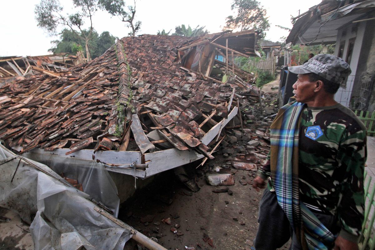 Cianjur, 2022. november 21.Megrongálódott lakóház romjait nézi egy férfi a Jáva szigetén fekvő Cianjurban 2022. november 21-én, miután 5.6-os erősségű földrengés rázta meg a várost és környékét. A természeti katasztrófának legkevesebb 56 halálos áldozata és 700 sérültje van