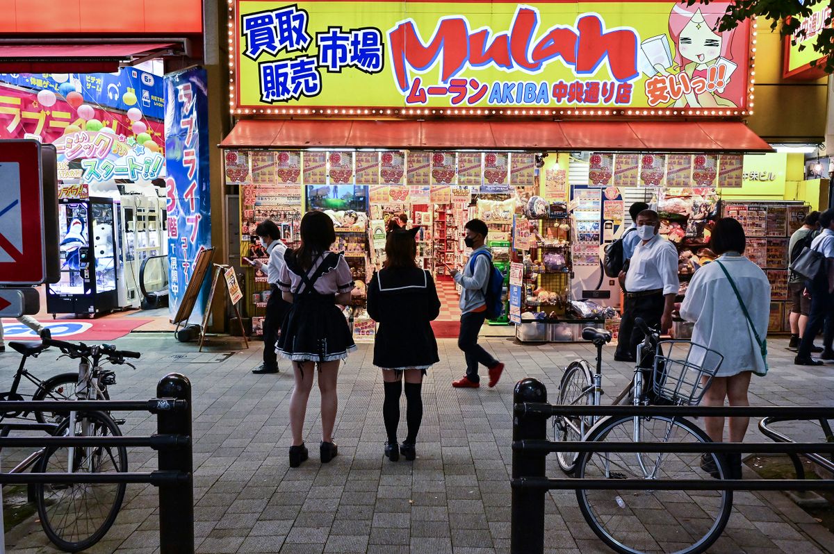 Pedestrians walk past a shop in the popular electronics shopping area of Akihabara in Tokyo on September 21, 2022. 