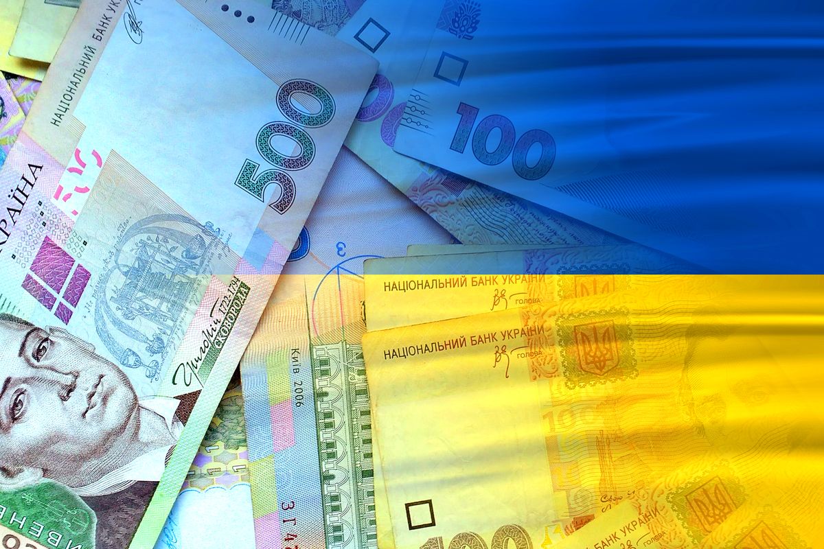 Hryvnia cash banknotes and Ukraine flag - Ukrainian money Hryvnia cash banknotes and Ukraine flag (money, economy, business, finance, inflation, crisis)