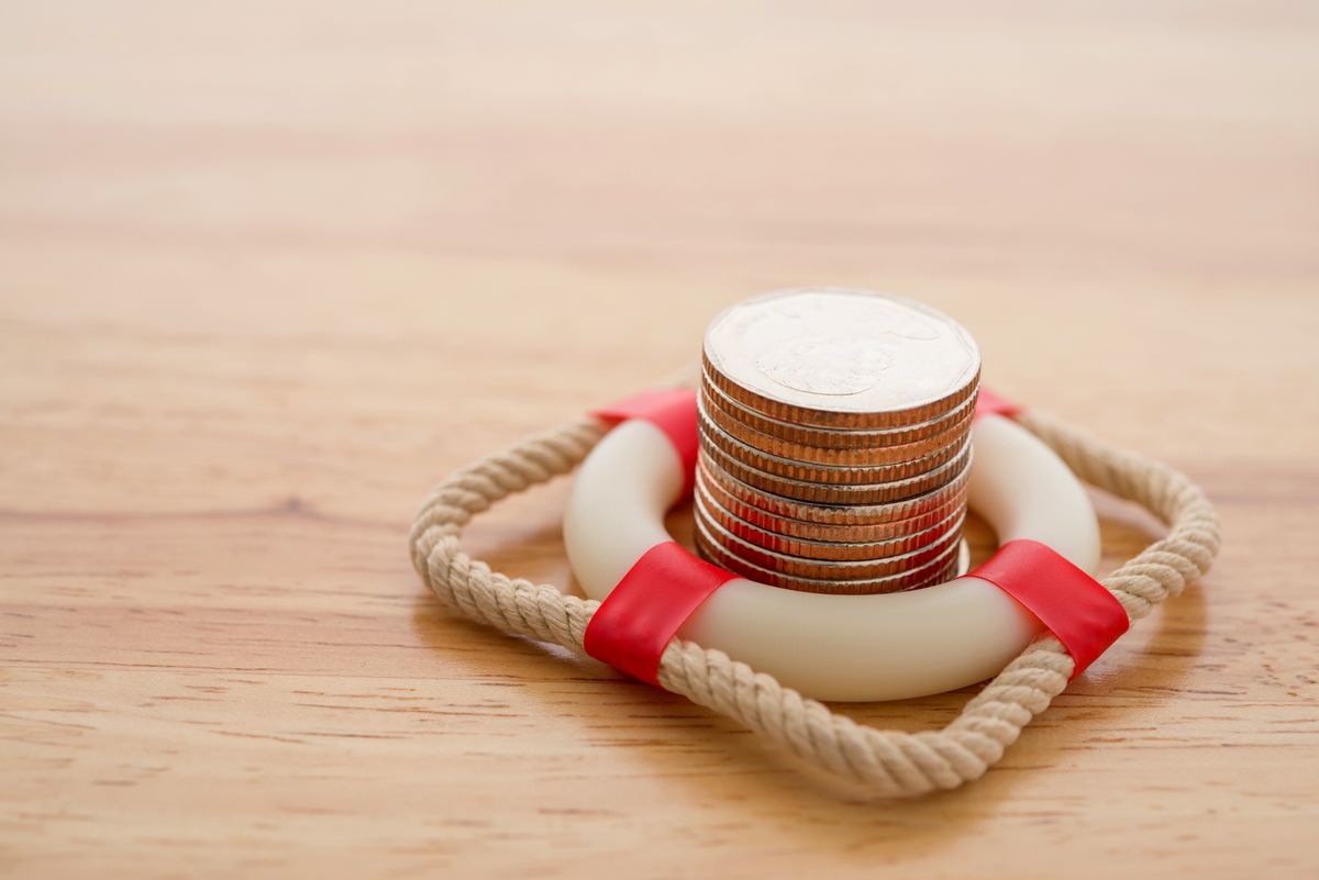 Stacked,Coins,In,Red,Lifebuoy,Or,Lifebelt,With,Wooden,Background, Stacked coins in red lifebuoy or lifebelt with wooden background copy space. Assets wealth, money saving or money investment protection and security by insurance concept. Risk management analysis.