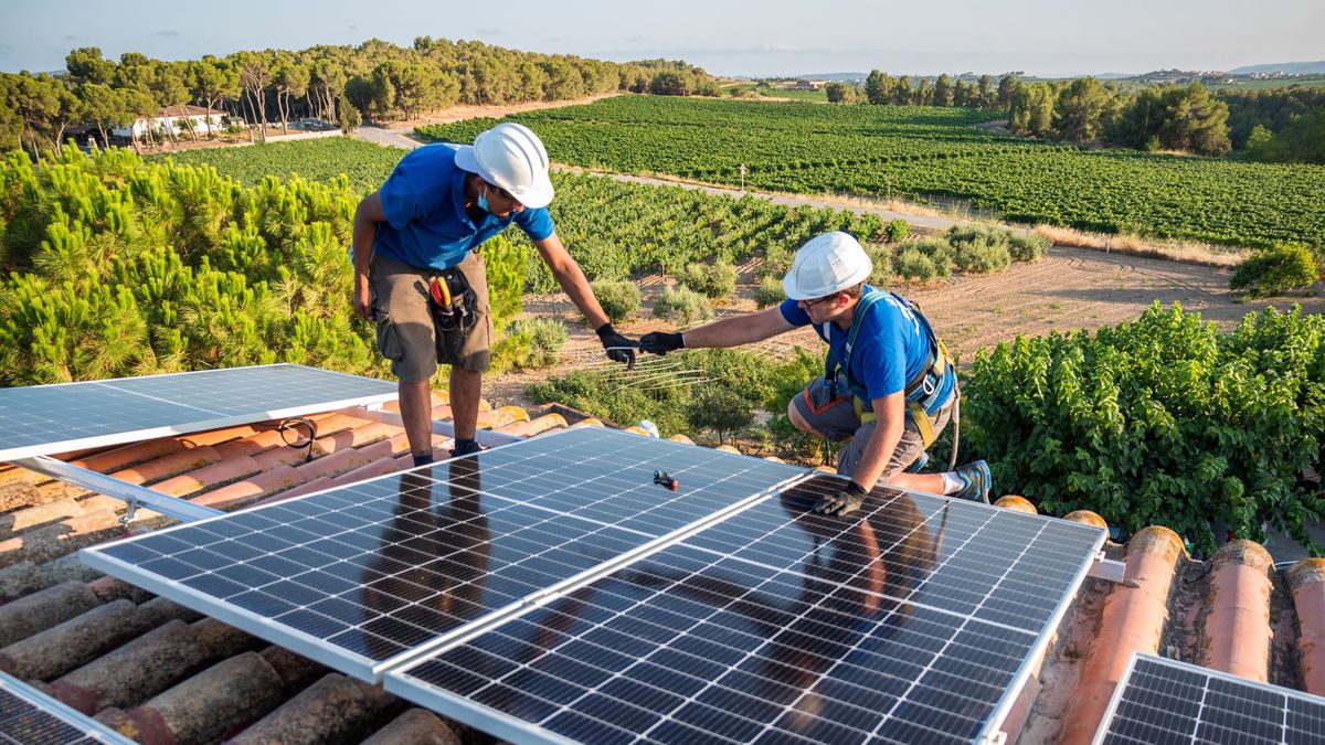 Two workers installing solar panels, two technicians passing each other a tool while installing a solar panel, napelem, nap, panel, napenergia, 