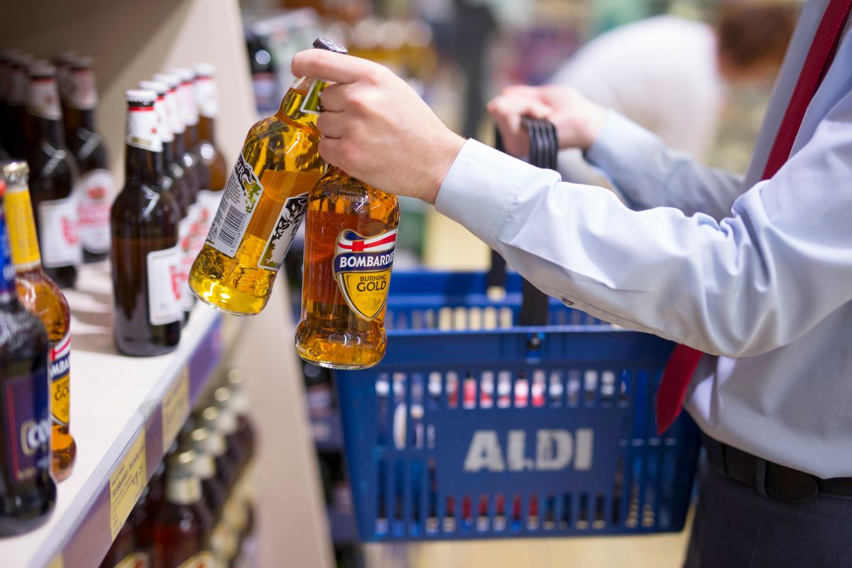 Inside Aldi The German Discount Supermarket, A customer fills his shopping basket with two bottles of Bombardier Burning Gold beer, brewed by Wells & Young's Brewing Company Ltd., inside an Aldi supermarket store in London, U.K., on Monday, June 29, 2015. The growth of Aldi and fellow German-owned discounter Lidl has changed the British grocery landscape over the last five years. Photographer: Jason Alden/BloombergA customer fills his shopping basket with two bottles of Bombardier Burning Gold beer, brewed by Wells & Young's Brewing Company Ltd., inside an Aldi supermarket store in London, U.K., on Monday, June 29, 2015. The growth of Aldi and fellow German-owned discounter Lidl has changed the British grocery landscape over the last five years. Photographer: Jason Alden/Bloomberg, A customer fills his shopping basket with two bottles of Bombardier Burning Gold beer, brewed by Wells & Young's Brewing Company Ltd., inside an Aldi supermarket store in London, U.K., on Monday, June 29, 2015. The growth of Aldi and fellow German-owned discounter Lidl has changed the British grocery landscape over the last five years. Photographer: Jason Alden/Bloomberg via Getty Images