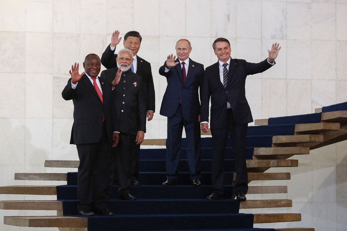 South Africa's President Cyril Ramaphosa (L), India's Prime Minister Narendra Modi (2nd L), China's President Xi Jinping (C), Russia's President Vladimir Putin (2nd R), Brazil's President Jair Bolsonaro (R) wave to press before posing for a family picture during the 11th BRICS Summit on November 14, 2019 in Brasilia, Brazil. - Brazil's President Jair Bolsonaro walked a diplomatic tightrope, as he seeks to boost ties with Beijing and avoid upsetting key ally Donald Trump, on the eve of a summit with their BRICS counterparts from Russia, India and South Africa. (Photo by Sergio LIMA / AFP)