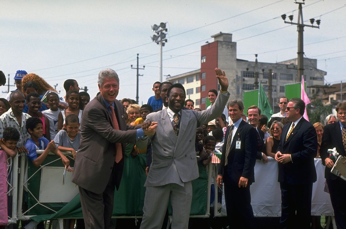 William J. Clinton;Pele US President Bill Clinton (L) & Brazilian soccer star Pele (R) joining hands, having high old time visiting Camp Mangueira, school & community center.    (Photo by Diana Walker/Getty Images)