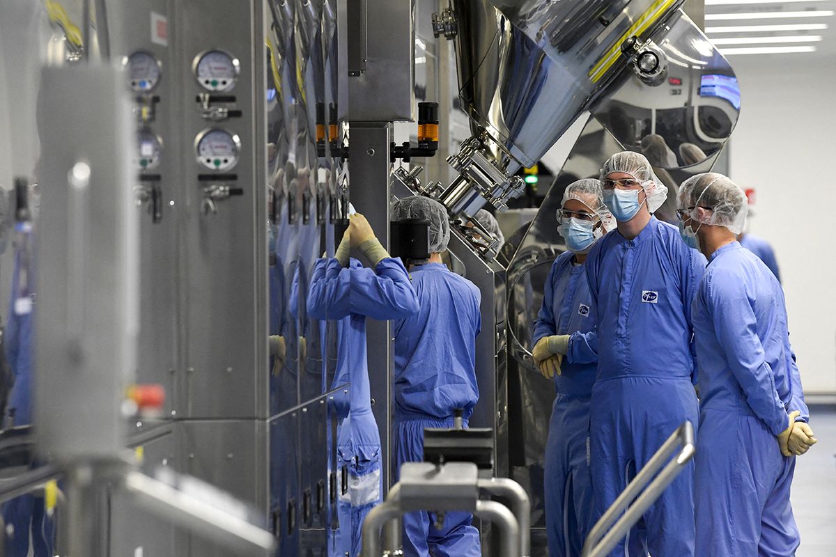 Employees are at work at the factory of US multinational pharmaceutical company Pfizer in Puurs during a visit of the European Commission President and the Belgium's Prime Minister on April 23, 2021. (Photo by JOHN THYS / POOL / AFP) BELGIUM-EU-HEALTH-VIRUS-VACCINE