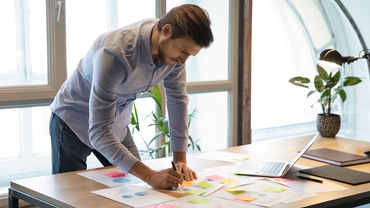 Thoughtful,Serious,Young,Businessman,Employee,Standing,At,Desk,Focused,On