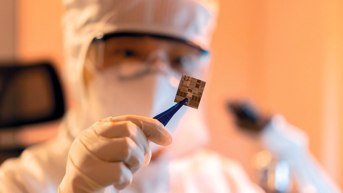 Female engineer inspecting wafer chip in dust-free laboratory, china, chip