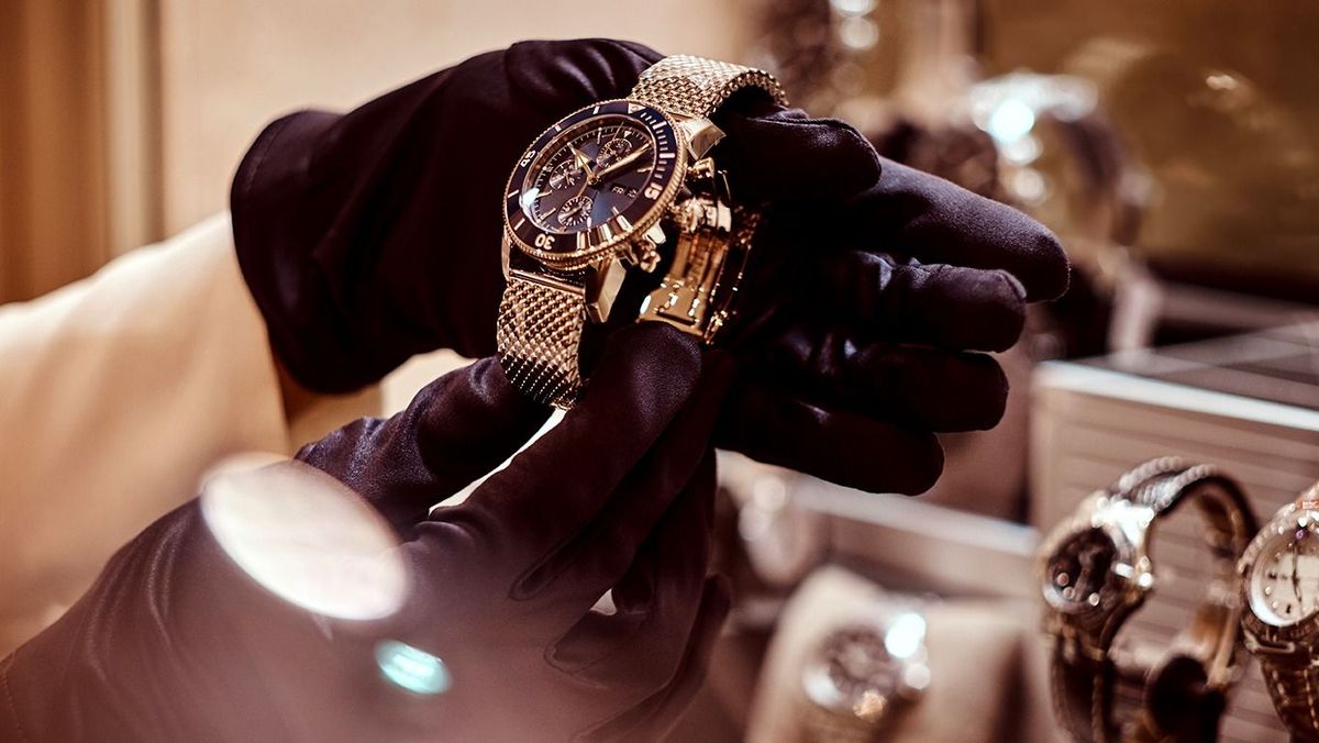 Close-up,Of,The,Seller's,Hands,In,Gloves,Shows,The,Exclusive Close-up of the seller's hands in gloves shows the exclusive men's watch from the new collection in the luxury jewelry store