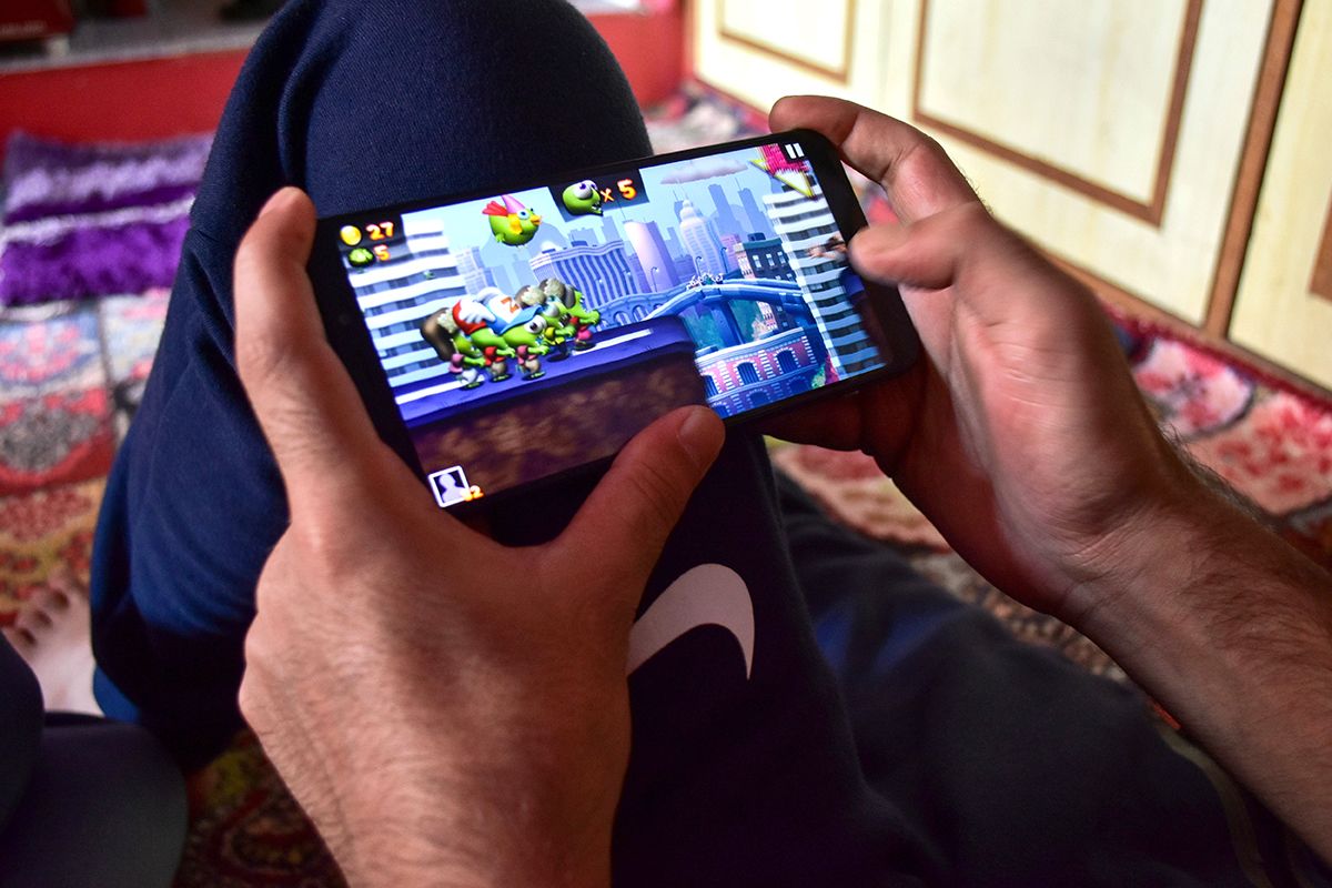 Hands of a man playing a game on a smartphone during the SRINAGAR, INDIA - 2019/09/07: Hands of a man playing a game on a smartphone during the shutdown in Srinagar.Communication blockade with mobile phones and Internet services continued to remain shutdown on 34th day here in Kashmir valley following the scrapping of Article 370 by the central government which grants special status to Jammu & Kashmir. However landline telephone services have been fully restored in the valley. (Photo Illustration by Saqib Majeed/SOPA Images/LightRocket via Getty Images)