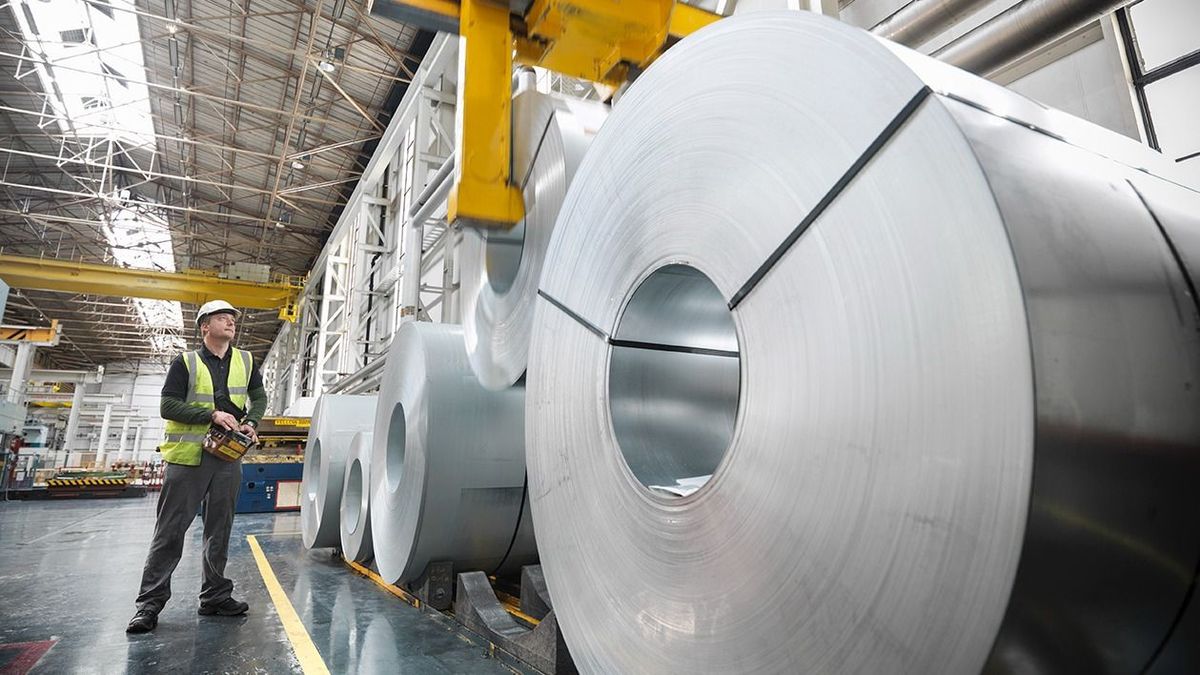 Worker operating crane with steel rolls in car factory, ipar, termelés, ksh