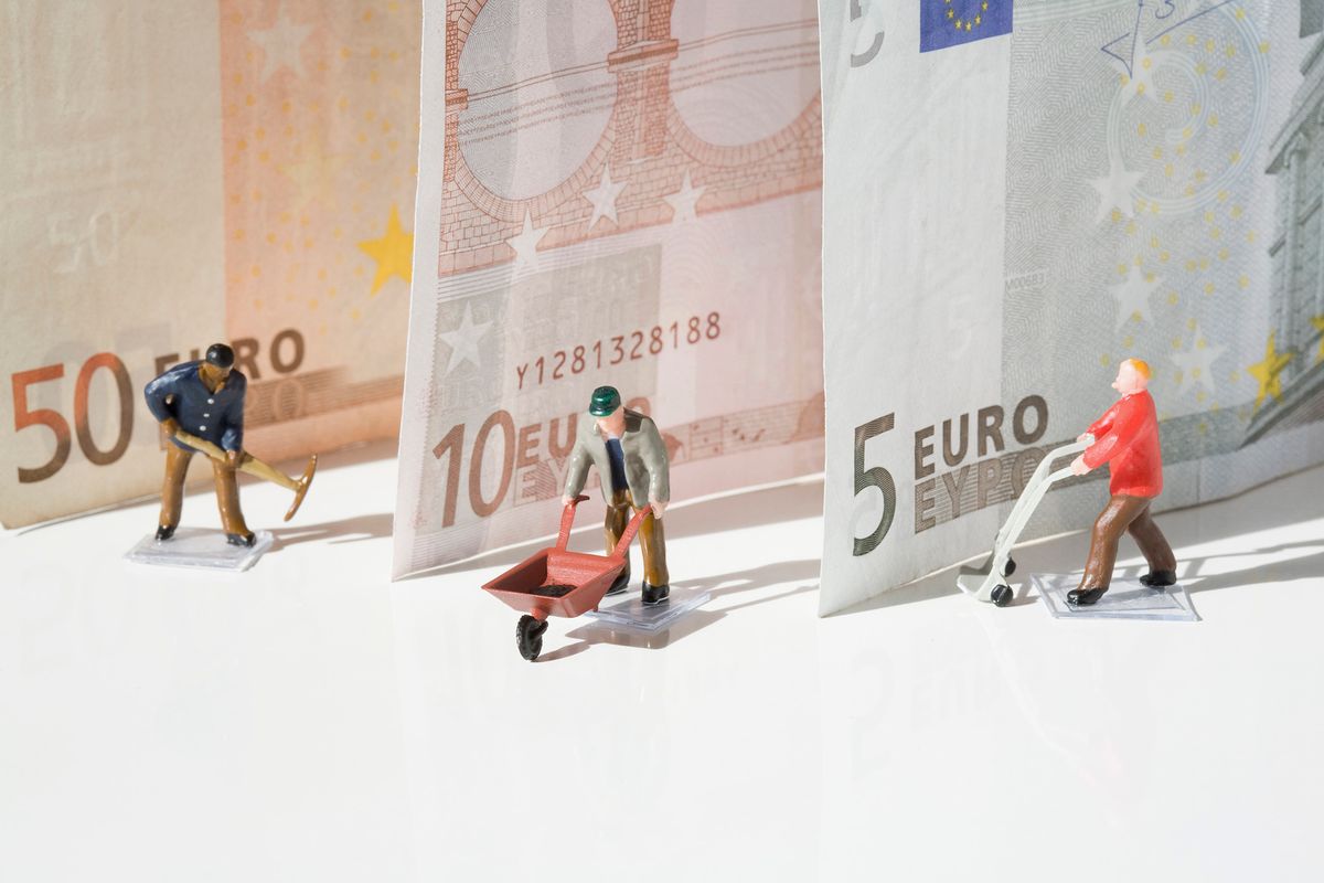 Figurines of manual workers with European union banknotes
