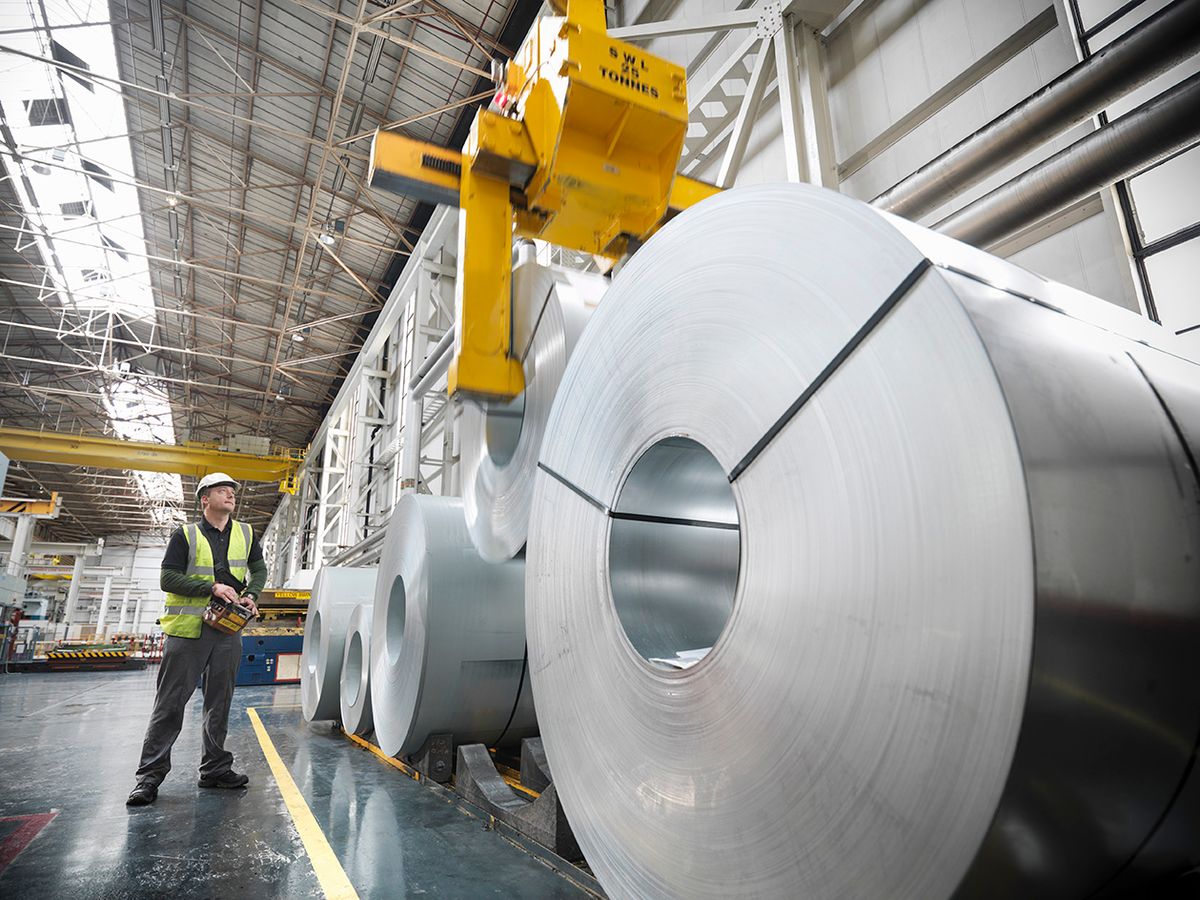 Worker operating crane with steel rolls in car factory, ipar, termelés, ksh