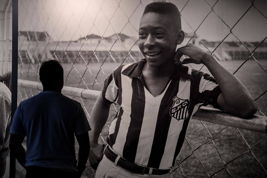 A visitor looks at a picture of Brazil's football legend Edson Arantes do Nascimento 'Pele', exhibited at the Pele Museum, in Santos, Brazil, on December 27, 2022. - Family members spent Christmas on Sunday with Pele at the Sao Paulo hospital where the legendary footballer is battling worsening cancer as well as kidney and heart problems, according to social media posts by his children. Fans of the player, considered by many the greatest of all time, have been expressing hope for his recovery since he was hospitalized in late November. (Photo by NELSON ALMEIDA / AFP)