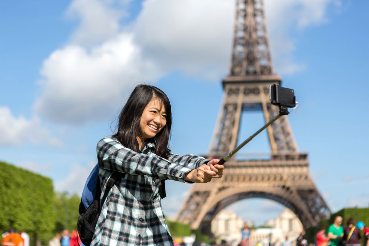 View of a Young attractive asian tourist in Paris taking selfie