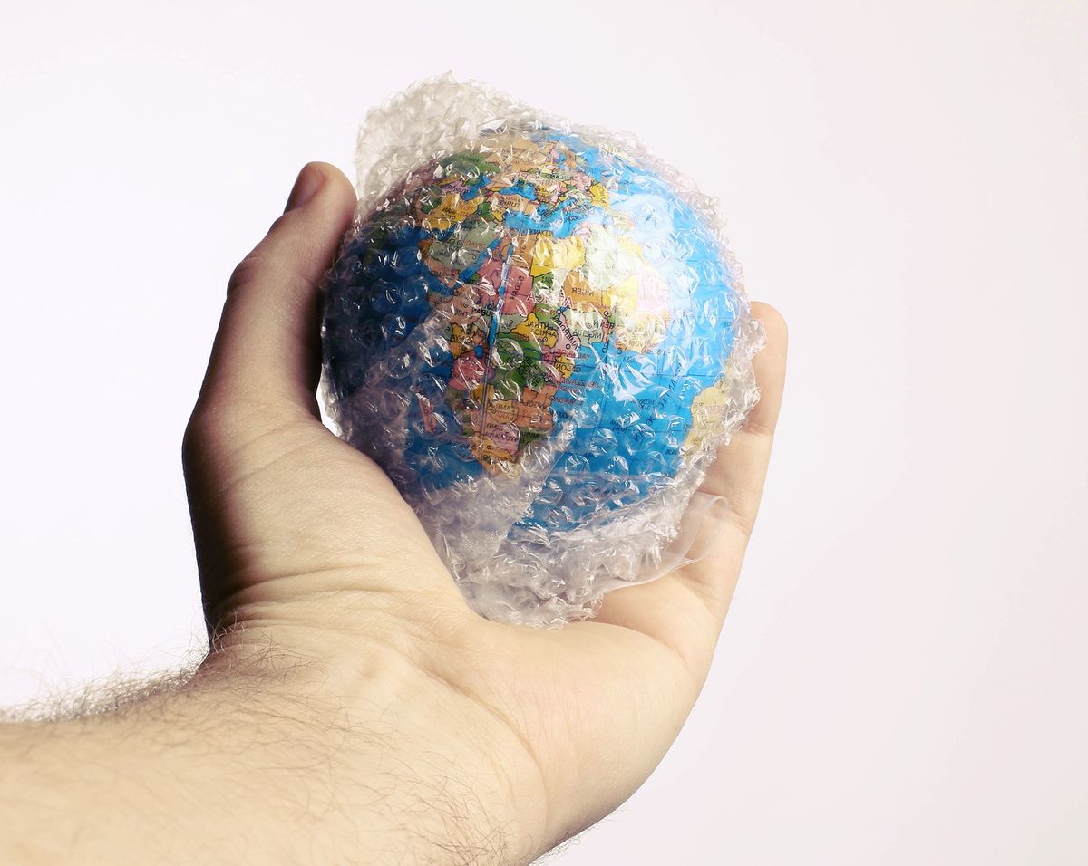 Hand,Holding,Globe,Packed,In,Bubble,Wrap