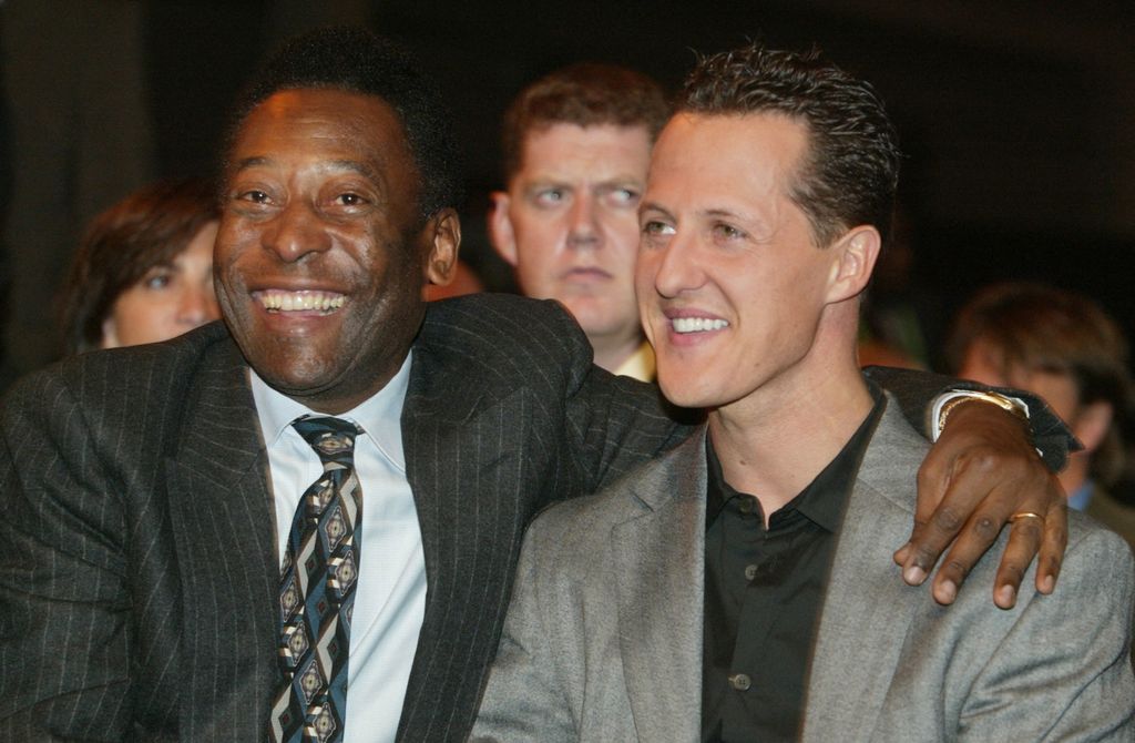 (FILES) In this file photo taken on December 05, 2003 Brazilian football legend Edson Arantes do Nascimento, Pele, embraces German Formula one world champion Michael Schumacher in Frankfurt at the start of the World Cup 2003 preliminary draw ceremony. - Brazilian football icon Pele, widely regarded as the greatest player of all time and a three-time World Cup winner who masterminded the 'beautiful game', died on December 29, 2022 at the age of 82, after battling kidney problems and colon cancer. (Photo by Thomas COEX / AFP)