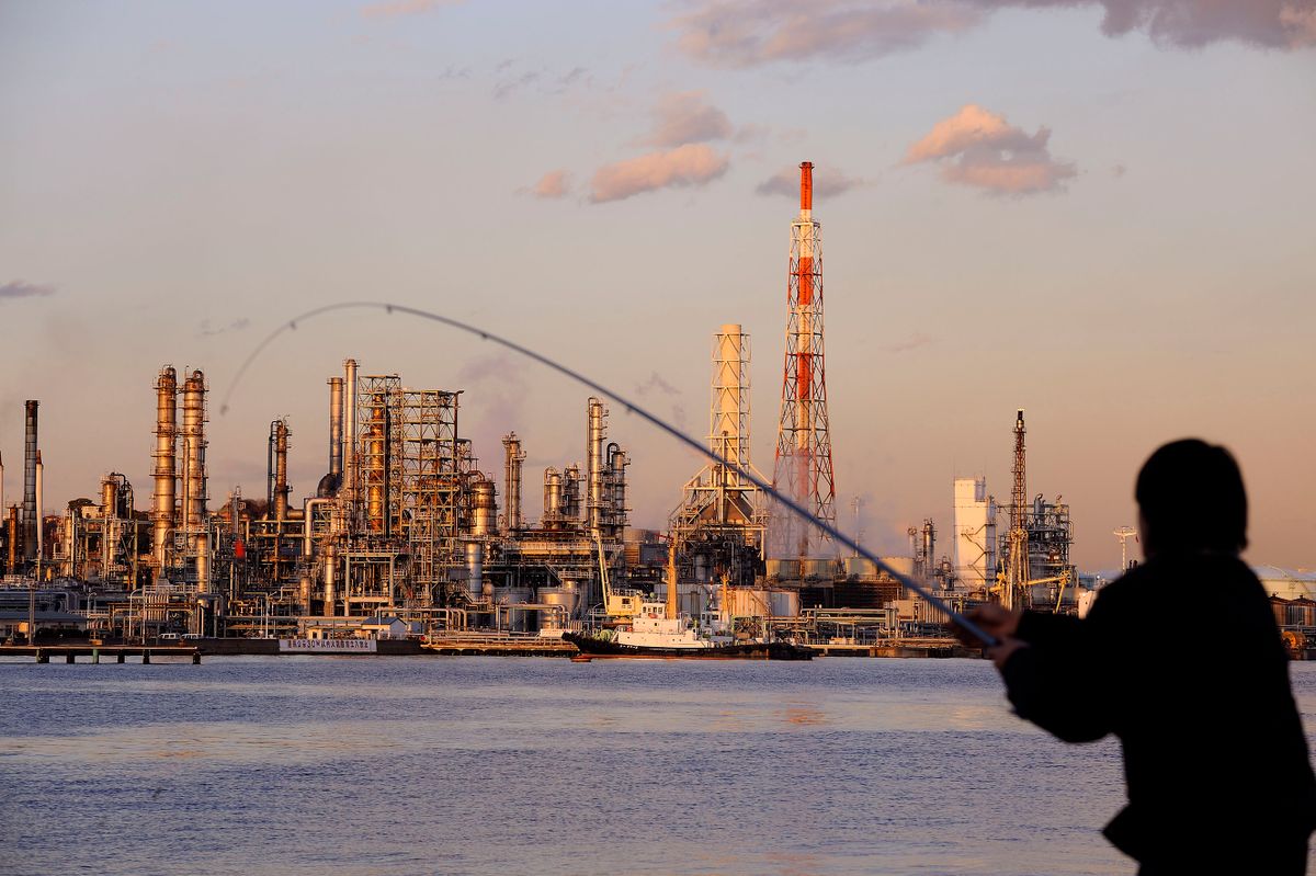 A fisherman casts his line opposite Nippon Oil Corp.'s Negishi refinery in Yokohama, Japan, on Tuesday, Jan. 13, 2009. Nippon Oil Corp., Japan's largest oil refiner, will close the Toyama processing plant ahead of schedule by the end of this month and turn it into an oil-storage terminal.