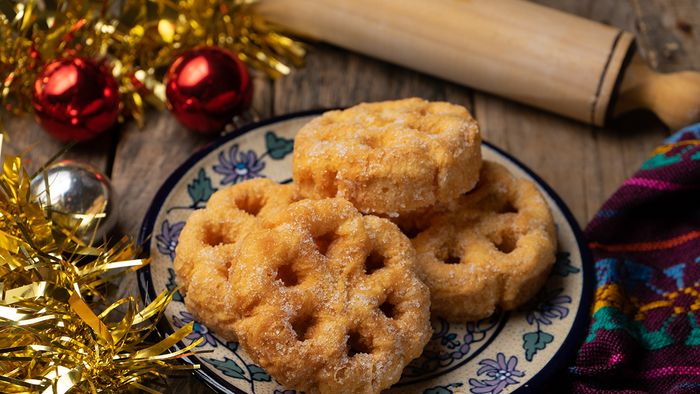 Mexican fritter with sugar and cinnamon called bunuelo on wooden background Traditional mexican fritter with sugar and cinnamon called bunuelo on wooden background