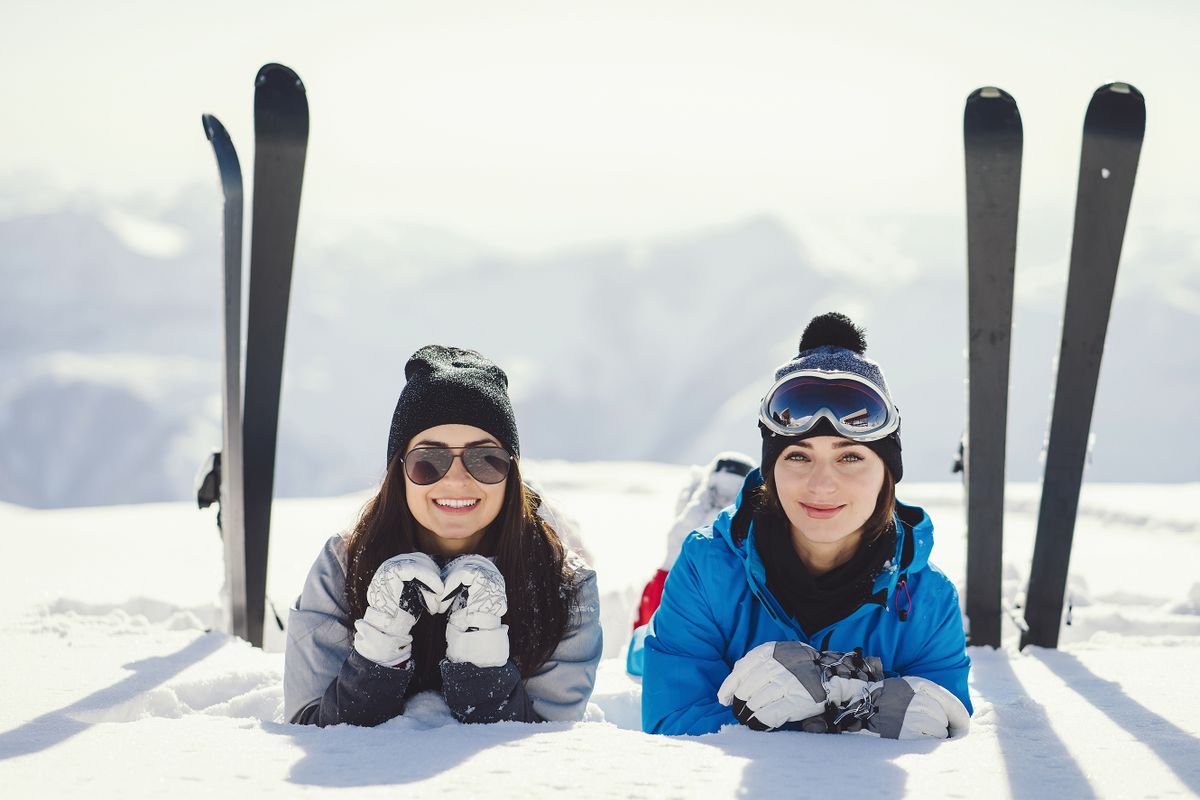 Two,Young,And,Active,Brunette,Sitting,In,The,Snowy,Mountains