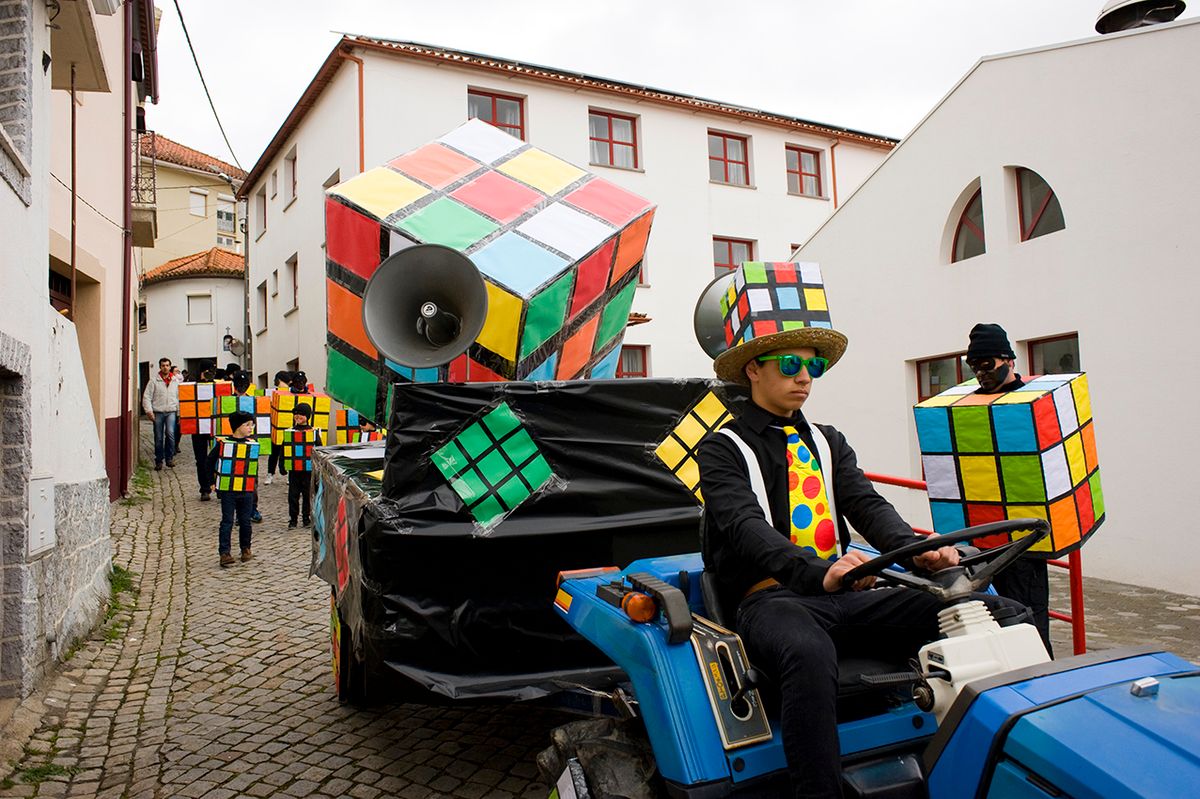 A tractor pulling a float leads kids dressed up as Rubik's COJA, ARGANIL, PORTUGAL - 2017/02/28: A tractor pulling a float leads kids dressed up as Rubik's cubes as they parade during the carnival procession in the mountain town of Coja. (Photo by Peter Charlesworth/LightRocket via Getty Images)
