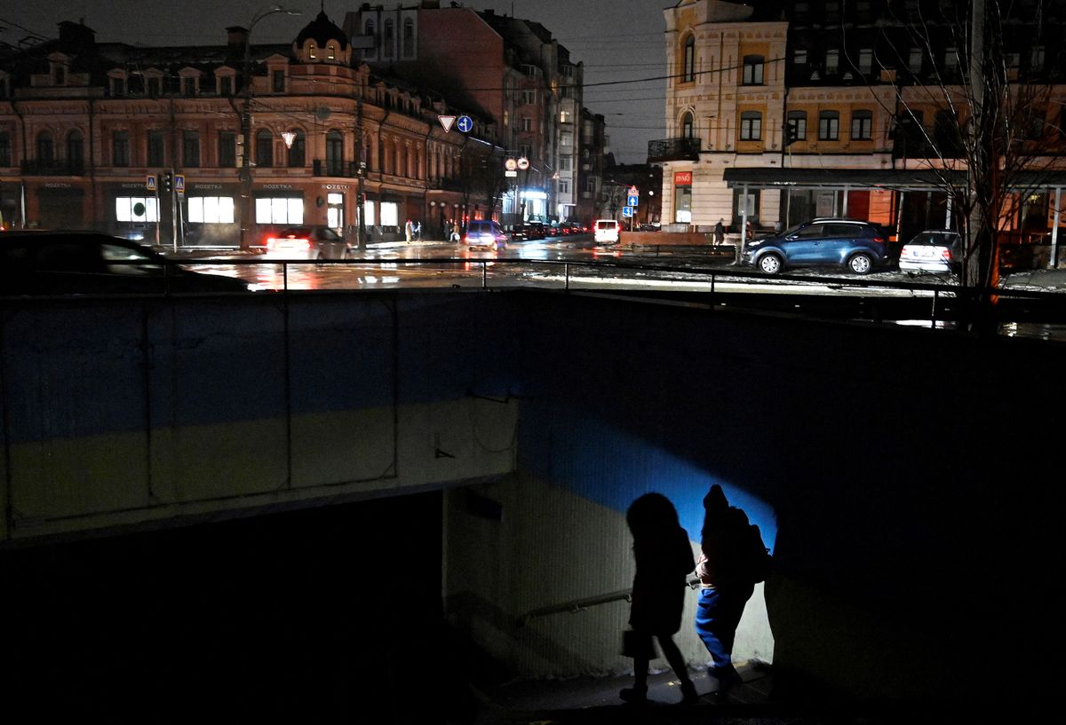 People use a flashlight as they enter an underground passage  during a blackout following Russian strikes on the power infrastructure in Kyiv on December 17, 2022, amid the Russian invasion of Ukraine. 