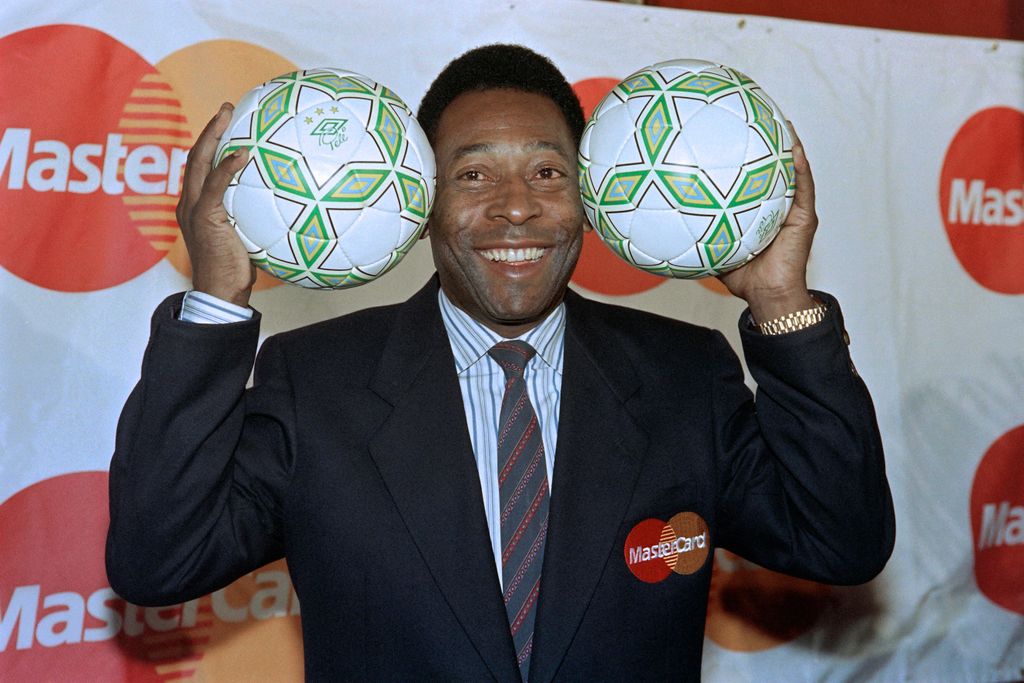 (FILES) In this file photo taken on April 01, 1992 Former Brazilian soccer star, Edson Arantes do Nascimento, known as Pelé (L), holds soccer balls at an appearance to promote his tie with a creit card company that is a sponsor of the 1994 World Cup, in New York. - Brazilian football icon Pele, widely regarded as the greatest player of all time and a three-time World Cup winner who masterminded the 'beautiful game', died on December 29, 2022 at the age of 82, after battling kidney problems and colon cancer. (Photo by Maria R. BASTONE / AFP)