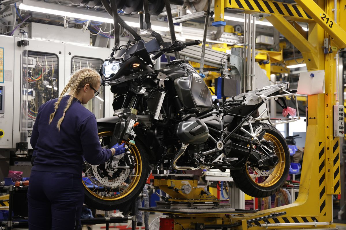 BERLIN, GERMANY - DECEMBER 19: A female trainee works on the assembly line at the BMW motorcycle manufacturing plant on December 19, 2022 in Berlin, Germany. The plant, opened in 1967, produces over 550 gasoline and electric powered motorcycles and scooters per day. 