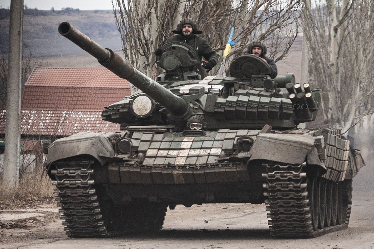 Ukrainian armed forces' soldiers drive a T-72 tank on the outskirts of Bakhmut, eastern Ukraine on December 21, 2022. - For civilians trying to survive in the hell of Bakhmut, the visit of Ukrainian President Volodymyr Zelensky on December 20, 2022 was a non-event. But it boosted the morale of soldiers engaged in one of the most violent battles on the front line.