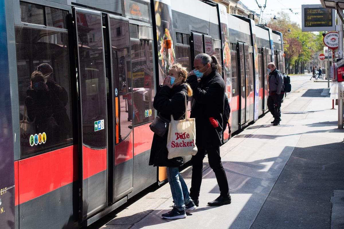 VIENNA, AUSTRIA - APRIL 15: People wearing a face mask enter a streetcar in the city center following an easing of restrictions during the coronavirus crisis on April 15, 2020 in Vienna, Austria. The Austrian government is taking the first steps towards lifting heavy restrictions on public life that had been out in place to stem the spread of the coronavirus, including the opening of small shops, gardening centers and home supplies retailers. People riding public transportation are required to wear a protective face mask. 