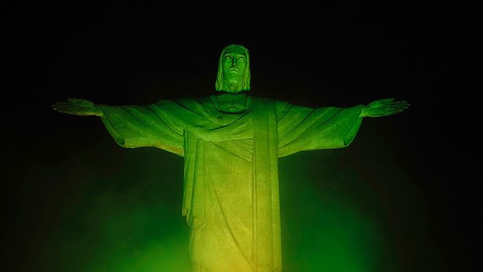 The Christ The Redeemer statue, on top of Corcovado mountain, is illuminated in green and yellow, the colours of the Brazilian national flag, in honour of Brazilian football legend Pele, in Rio de Janeiro, Brazil on December 29, 2022, just hours after his passing at a Sao Paulo hospital. - Brazilian football icon Pele, widely regarded as the greatest player of all time and a three-time World Cup winner who masterminded the "beautiful game," died on Thursday at the age of 82. The Albert Einstein hospital treating Pele said in a statement his death after a long battle with cancer was caused by "multiple organ failure." (Photo by Mauro PIMENTEL / AFP)