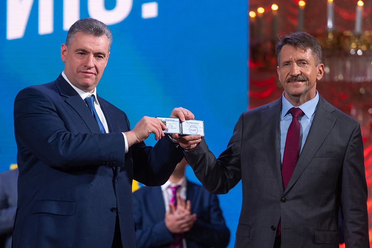 This handout photograph taken and released by the Liberal Democratic Party of Russia press service on December 12, 2022 shows Leonid Slutsky, the leader of the Liberal Democratic Party (L) and Viktor Bout showing his membership card at a convention of the Liberal Democratic Party of Russia (LDPR) in Moscow. - On December 8, 2022, Viktor Bout, who was serving a 25-year sentence in a US prison, was exchanged in Abu Dhabi for American basketball star Brittney Griner.
Viktor But
