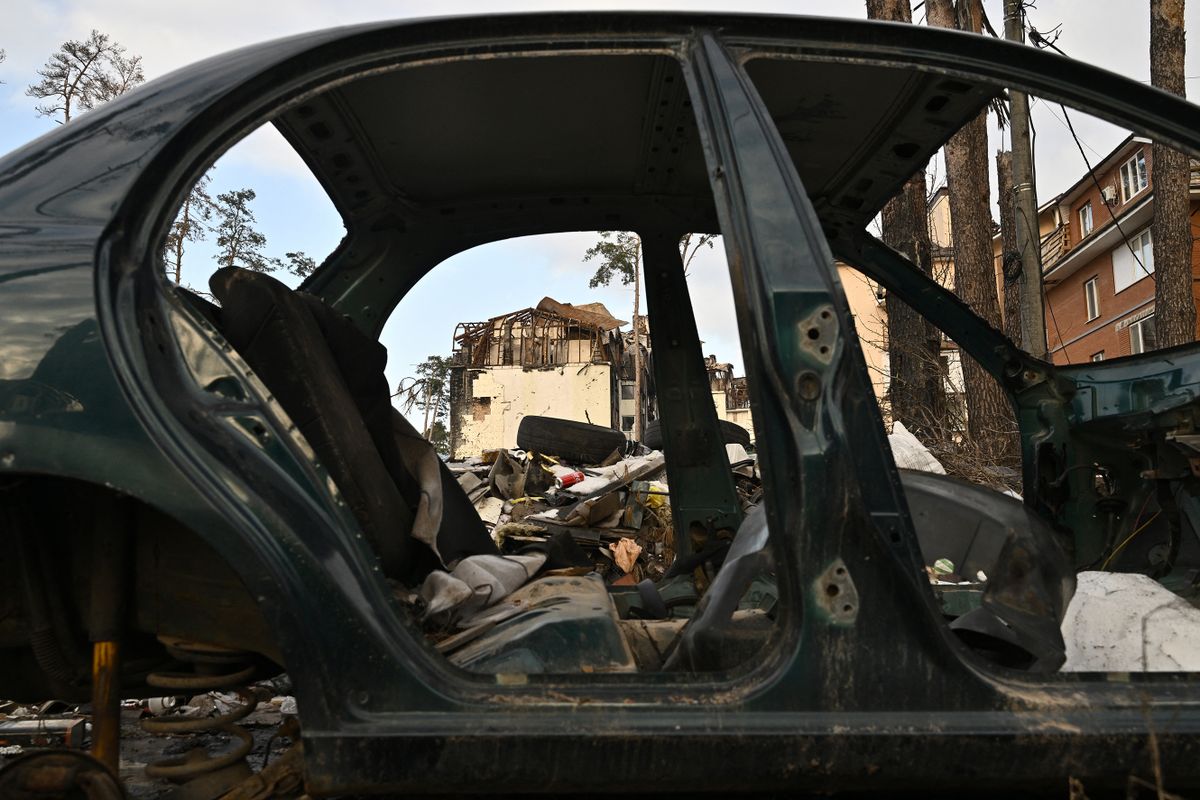 This photograph taken on December 23, 2022 shows heavily damaged residential buildings behind a destroyed car in Irpin, northwest of Kyiv, amid the Russian invasion of Ukraine. 