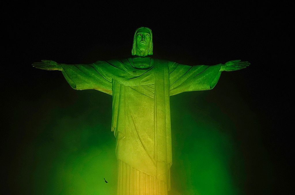 The Christ The Redeemer statue, on top of Corcovado mountain, is illuminated in green and yellow, the colours of the Brazilian national flag, in honour of Brazilian football legend Pele, in Rio de Janeiro, Brazil on December 29, 2022, just hours after his passing at a Sao Paulo hospital. - Brazilian football icon Pele, widely regarded as the greatest player of all time and a three-time World Cup winner who masterminded the "beautiful game," died on Thursday at the age of 82. The Albert Einstein hospital treating Pele said in a statement his death after a long battle with cancer was caused by "multiple organ failure." (Photo by Mauro PIMENTEL / AFP)