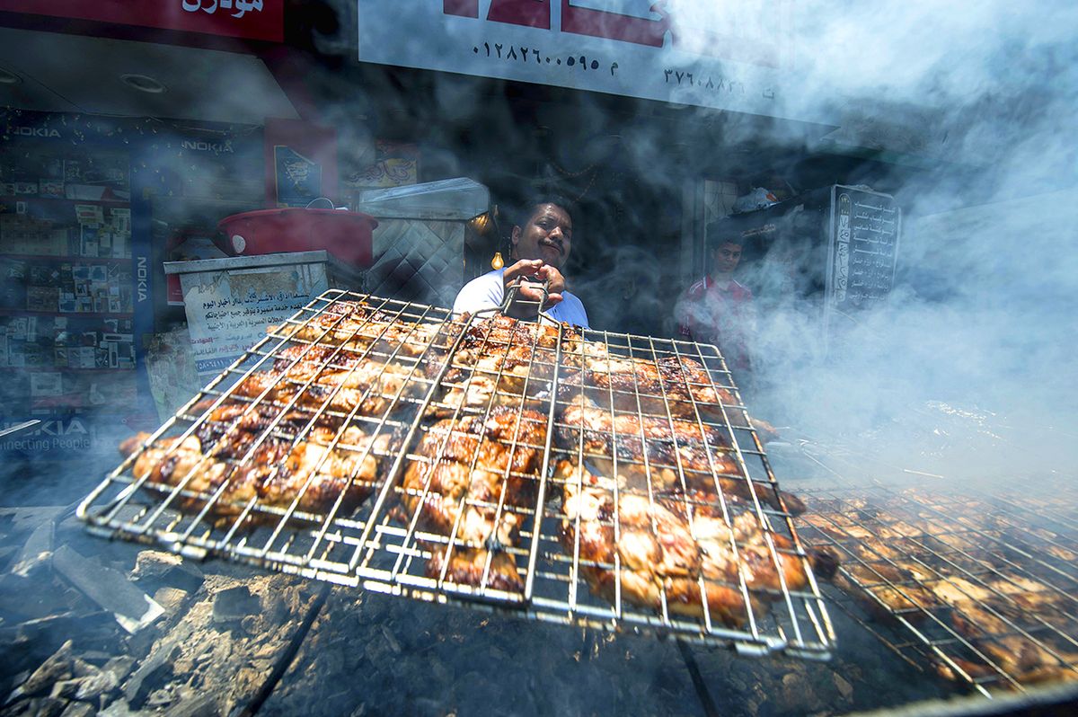 Egyptian cook Fathi grills chicken outside a restaurant in the Egyptian capital Cairo on June 21, 2016. - More than a billion people around the world are marking Ramadan this month, when Muslim faithful abstain from eating, drinking, smoking and having sex from dawn to dusk. Determined by the lunar hijri calendar, which has 11 days fewer than the solar Gregorian calendar, Ramadan shifts back every year. For the first time since 1983, in 2016 it falls at the same time as the longest days of the year. (Photo by KHALED DESOUKI / AFP) / TO GO WITH AFP STORY BY MARAM MAZEN
Egyiptom csirkeláb