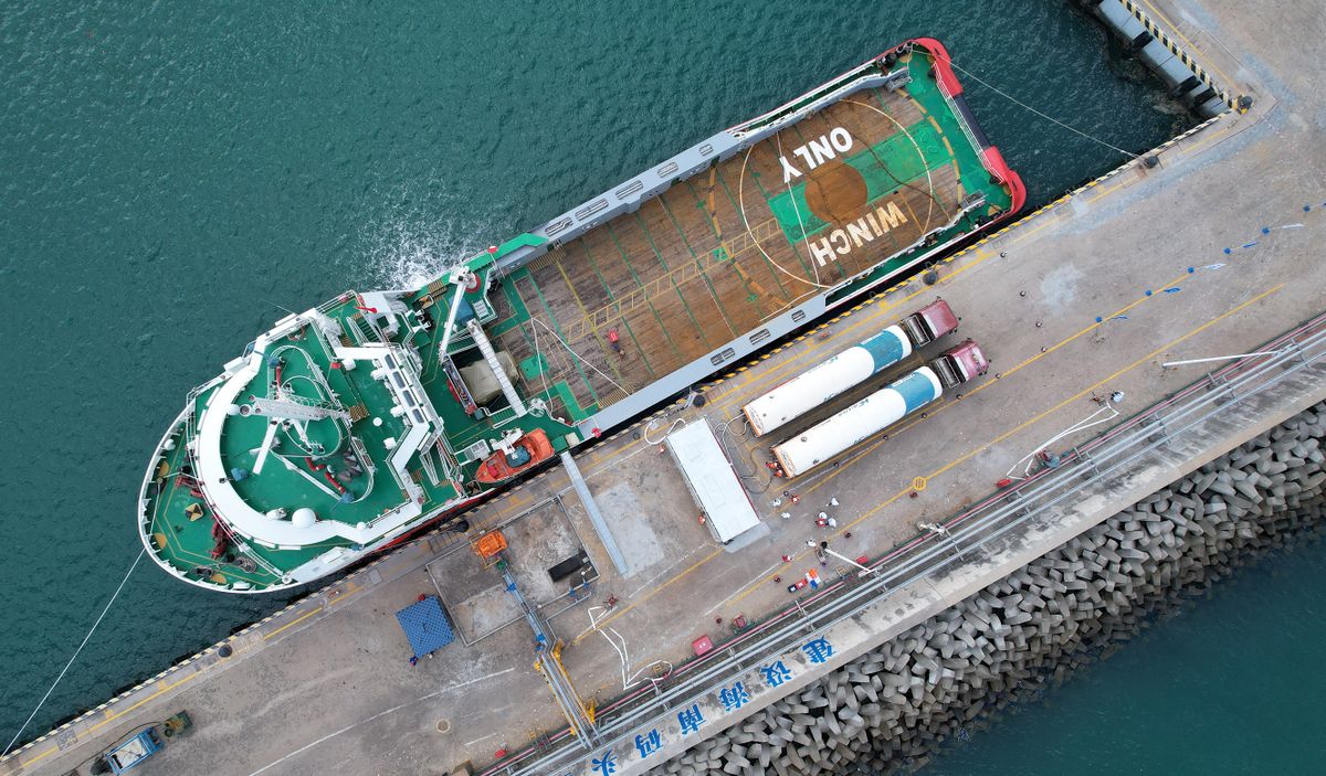 (211121) -- HAIKOU, Nov. 21, 2021 (Xinhua) -- Aerial photo taken on Nov. 20, 2021 shows a berthed ship being filled with liquefied natural gas (LNG) at an LNG filling station in Macun port of Chengmai County, south China's Hainan Province. The offshore LNG filling station, built and operated by China National Offshore Oil Corporation (CNOOC) Gas & Power Group, opened for operation on Saturday in Macun port of Hainan Province.