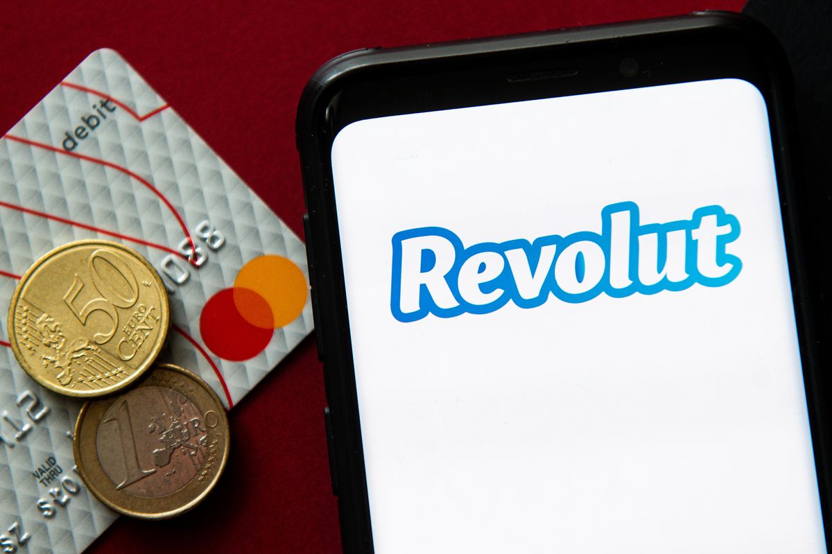 In this photo illustration a Revolut logo seen displayed on