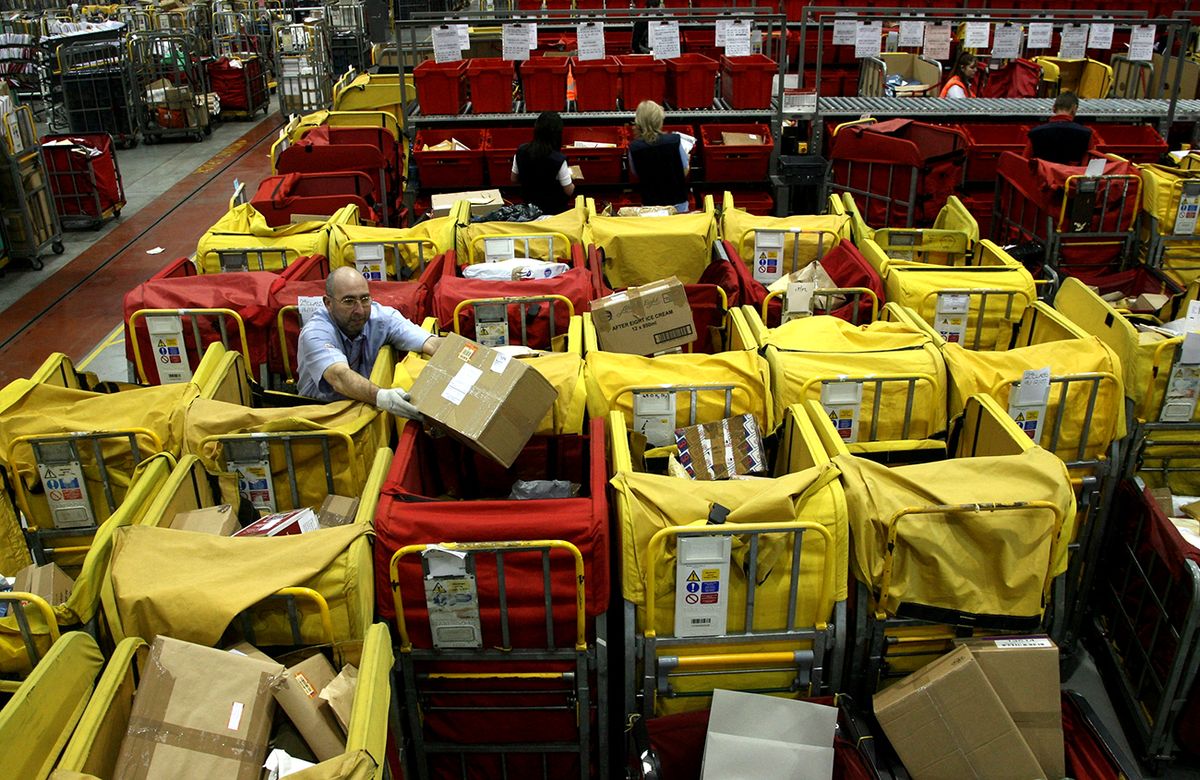 Post Office Processes Final Mail For Xmas Deadline BRISTOL, UNITED KINGDOM - DECEMBER 19:  Royal Mail postal worker Ian Tanner stacks crates with parcels in the Royal Mail Regional Sorting Office in Filton on December 19 near Bristol, England. Tomorrow is the last recommended day for posting First Class mail to meet the Christmas deadline.  (Photo by Matt Cardy/Getty Images)