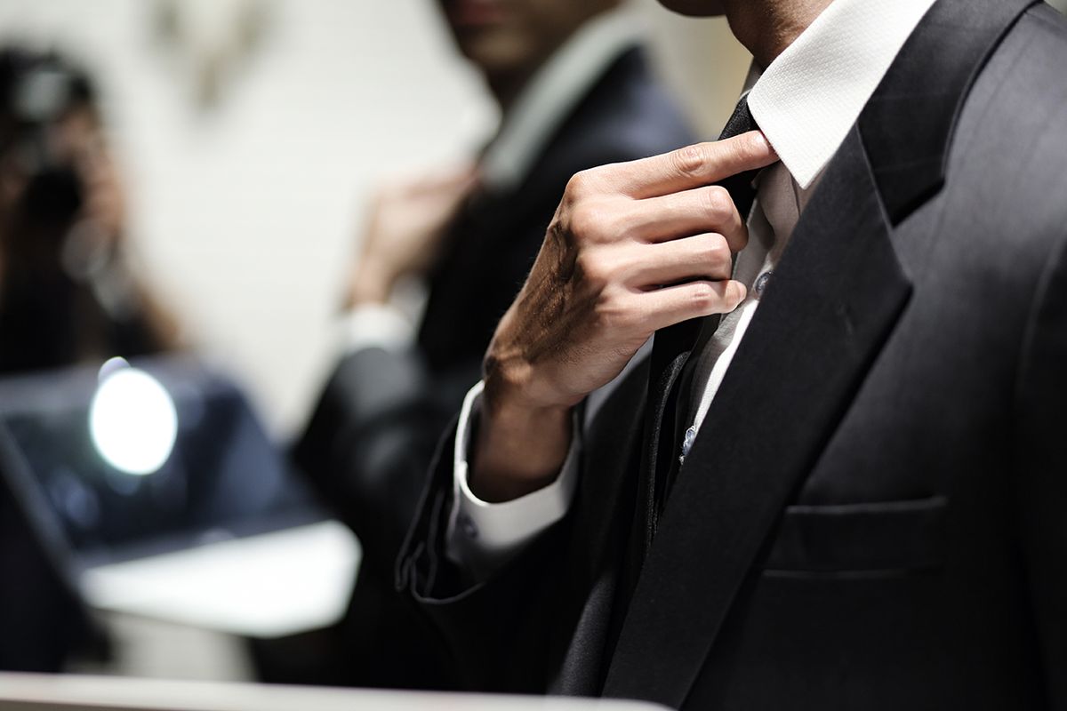 Close up of businessman adjusting necktie