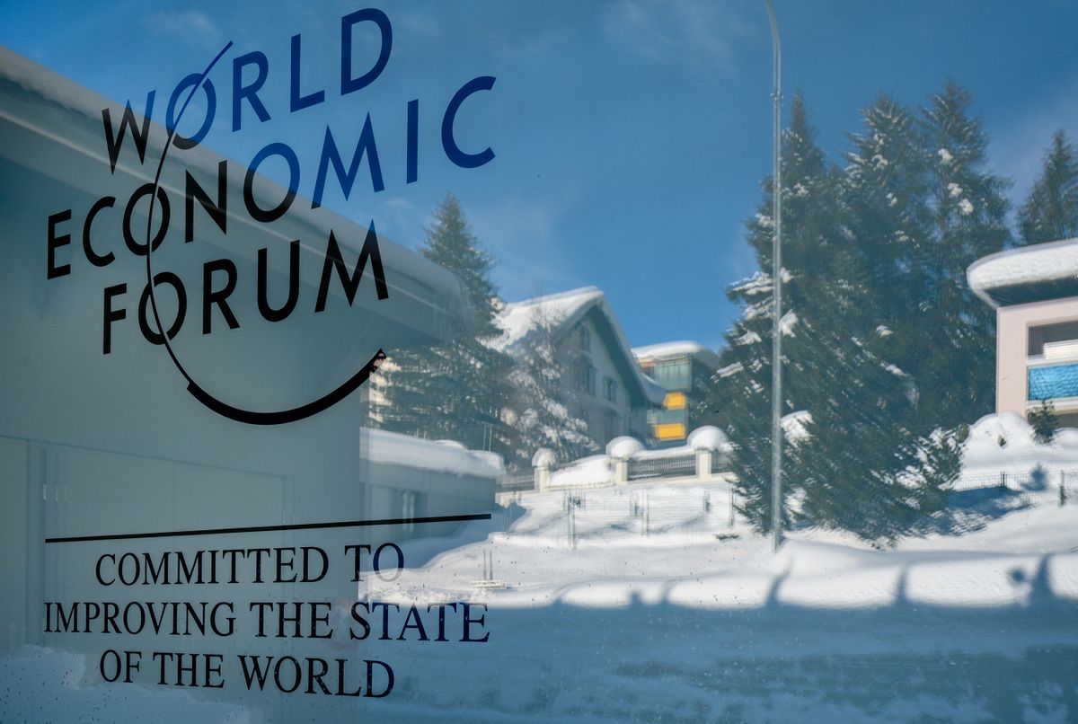 DAVOS, SWITZERLAND - JANUARY 17, 2019  : Emblem of the annual  World Economic Forum on Congress Hall glass display with blurred reflection of winter background in Davos, Switzerland.