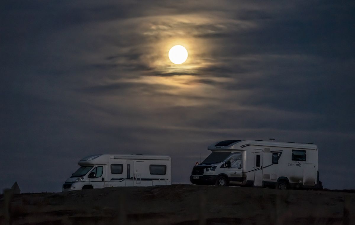 The moon sets behind a campervan parked in the North York Moors National Park in Yorkshire. The first full moon of 2022 - the Wolf moon according to native north Americans - is Monday evening. Picture date: Monday January 17, 2022.
