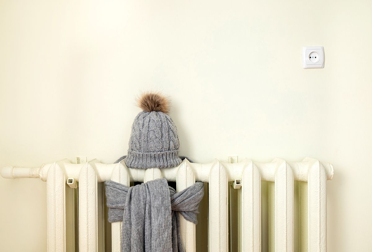 Vintage heating radiator with wool knitted winter hat and scarf. The electricity and gas bill goes up, European energy crisis concept. Background copy space, room for text. Vintage heating radiator with wool knitted winter hat and scarf. The electricity and gas bill goes up, European energy crisis concept. Background copy space, room for text.