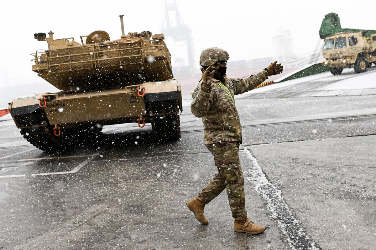 A US Army soldier signals the way to a M1A2 Abrams battle tank that will be used for military exercises by the 2nd Armored Brigade Combat Team, at the Baltic Container Terminal in Gdynia on December 3, 2022. - The military equipment arrived in Poland as part of the Operation Atlantic Resolve, augmenting the air, ground and naval presence along the Eastern flank of the NATO.
