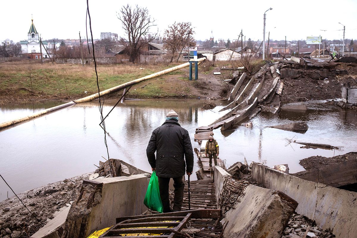 Bakhmut under attack by Russian Army BAKHMUT, UKRAINE - December 18: Bakhmut under daily Russian shelling, still daily life goes on despite near by Russian Army. Frontline is 2km from city in south direction. Old man tries to cross a improvised pontoon bridge with help of Ukrainian soldier. Bakhmut, on December 18, 2022. Andre Luis Alves / Anadolu Agency (Photo by Andre Luis Alves / ANADOLU AGENCY / Anadolu Agency via AFP)