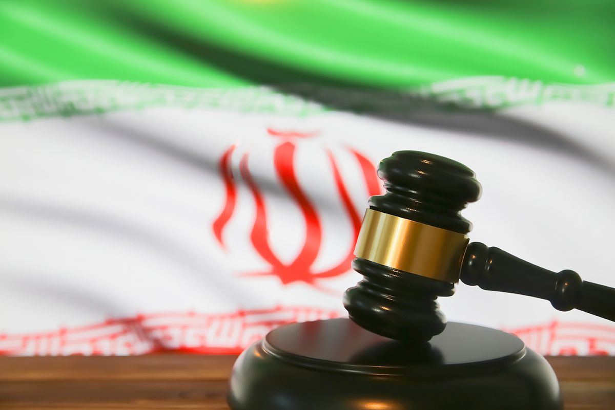 Closeup,Of,Isolated,Judge,Wood,Gavel,With,Blurred,Iran,Flag Closeup of isolated judge wood gavel with blurred iran flag background (focus on center of hammer head)