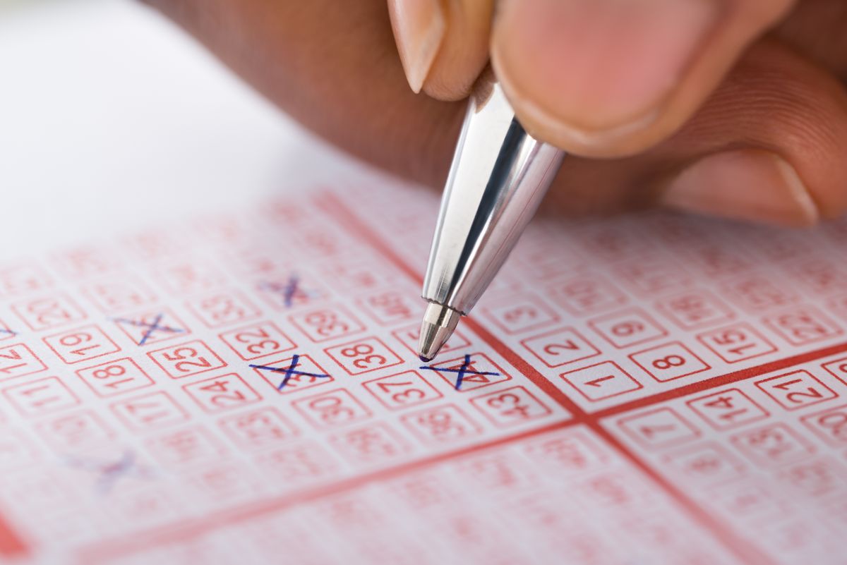 Close-up,Of,Person's,Hand,Marking,Number,On,Lottery,Ticket,With