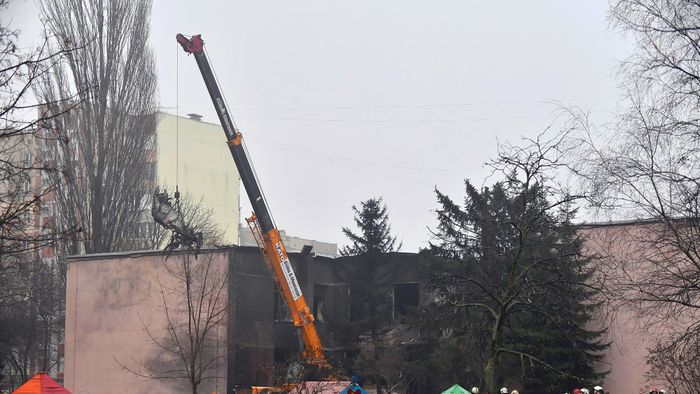 A part of a helicopter that crashed near a kindergarten is removed as rescuers work in Brovary, outside the capital Kyiv, on January 18, 2023, amid the Russian invasion of Ukraine. - Eighteen people, including Ukraine´s interior minister and three children, were killed in a helicopter crash near a kindergarten outside Kyiv on January 18, 20223. (Photo by Sergei SUPINSKY / AFP)
