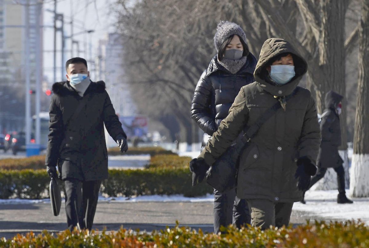 People wearing face masks to prevent COVID-19 infections walk in Pyongyang on Jan. 24, 2023. 
Phenjan