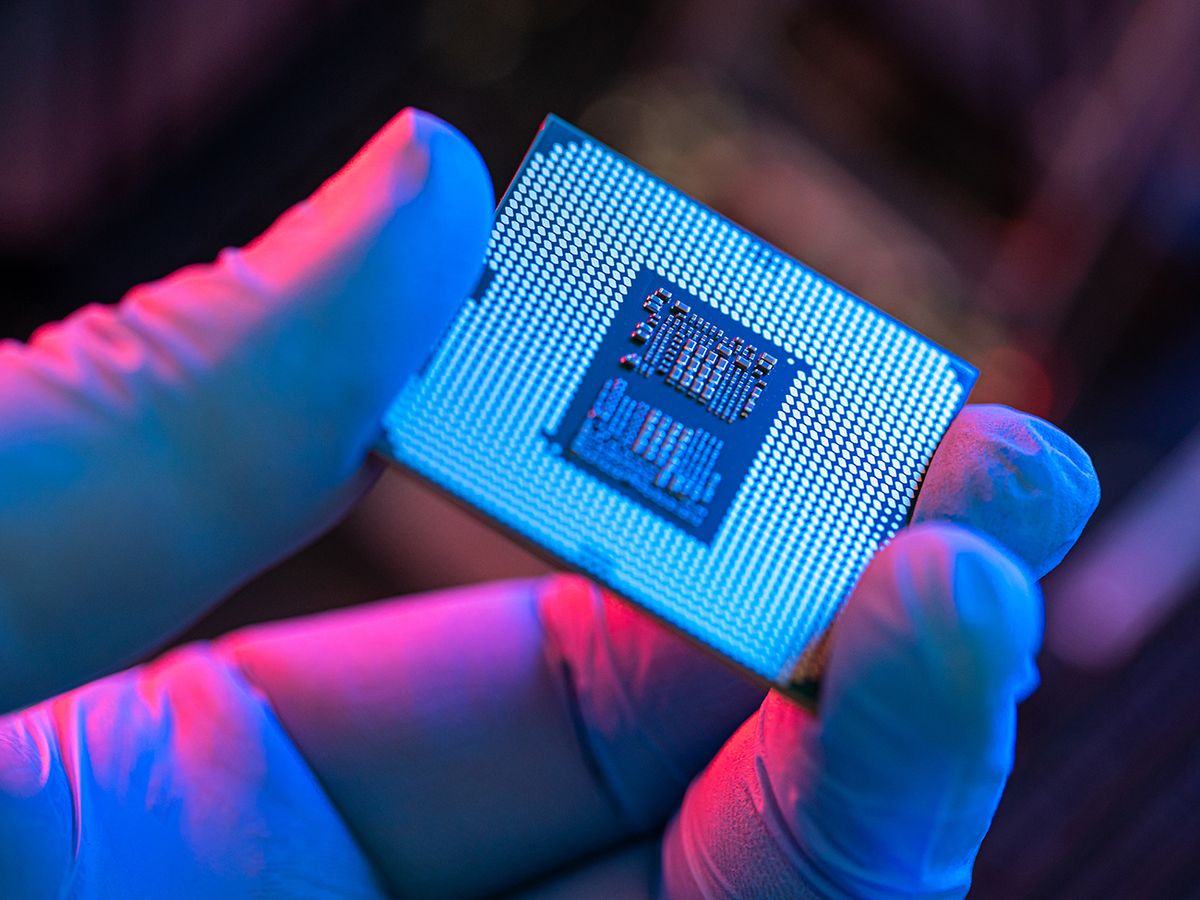 Close-up of person holding computer chip manipulating and installing processor on the motherboard in details with blur and selective focus