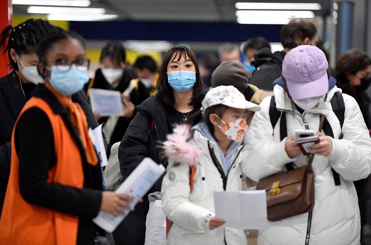 Passengers of a flight from China wait in a line for checking their COVID-19 vaccination documents as a preventive measure against the Covid-19 coronavirus, after arriving at the Paris-Charles-de-Gaulle airport in Roissy, outside Paris, on January 1, 2023. - France and Britain on December 30 joined a growing list of nations imposing Covid tests on travellers from China, after Beijing dropped foreign travel curbs despite surging cases -- and amid questions about its data reporting. (Photo by JULIEN DE ROSA / AFP)